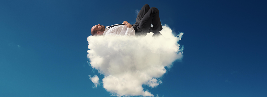 Un hombre en traje durmiendo en una nube esponjosa